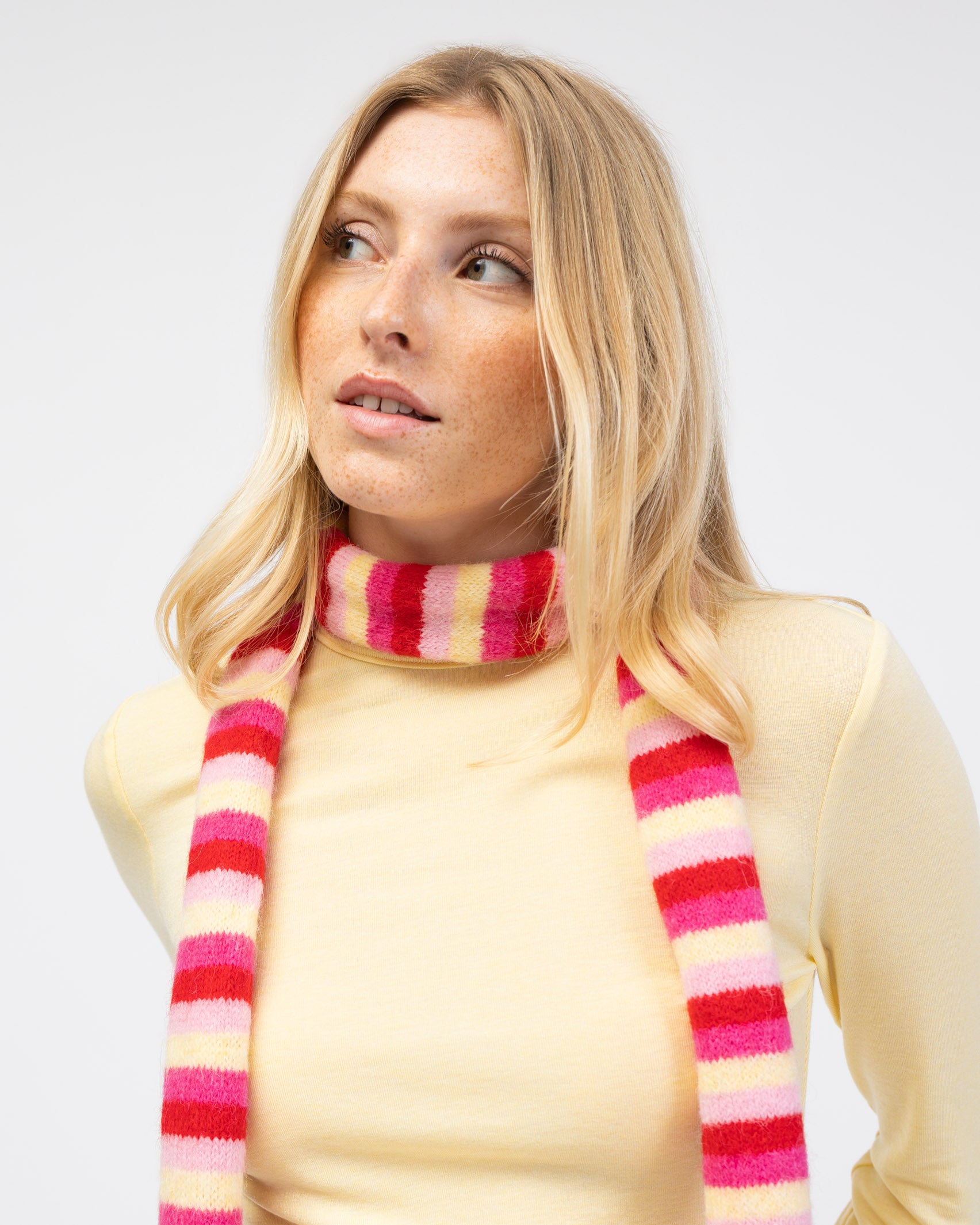 Gestreifter Schal mit hellen Farben kombiniert mit gelben Oberteil