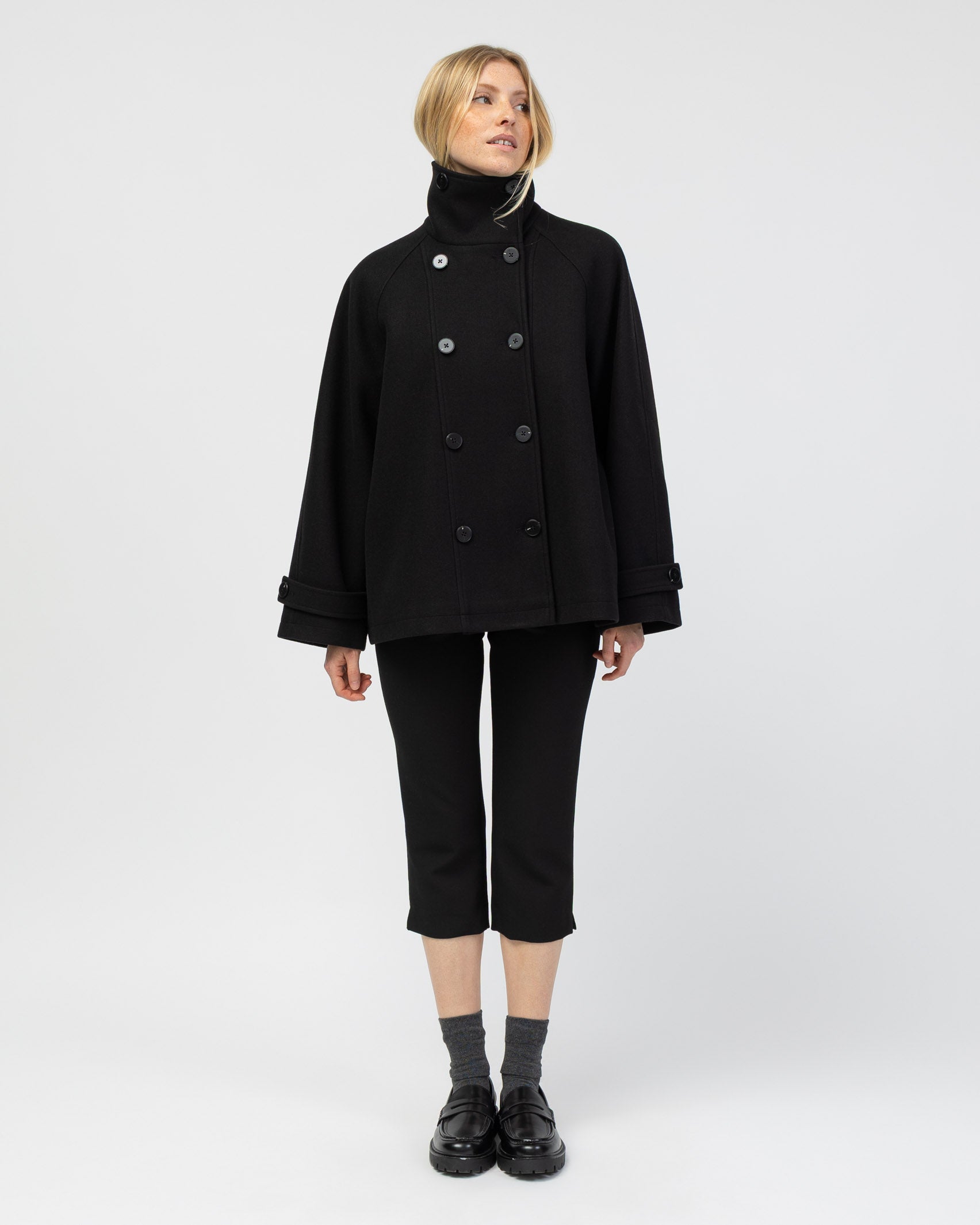 Mantel mit hohem Kragen kombiniert mit Capri Hose und Loafers