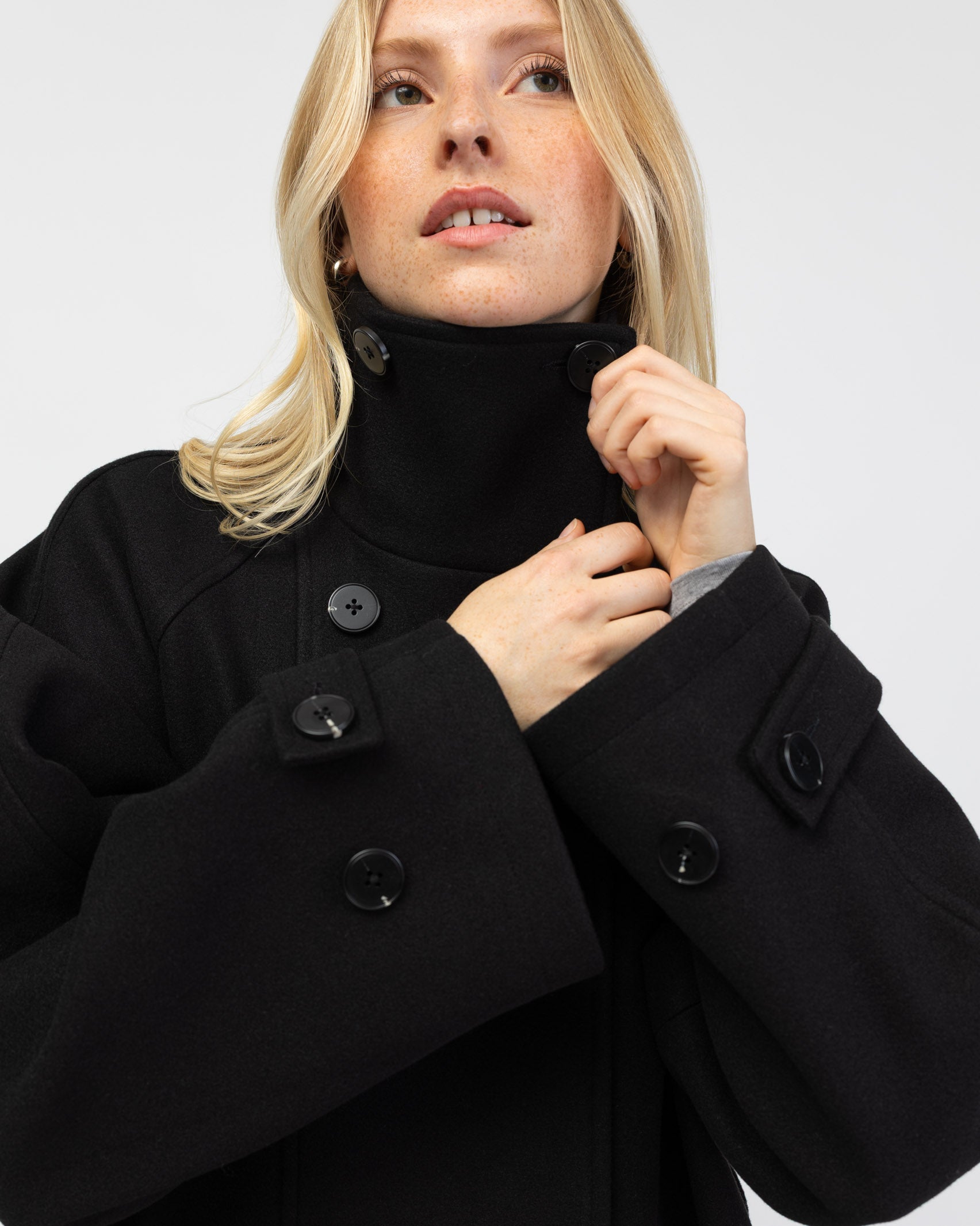 Langer Mantel mit hohem Kragen im Detail