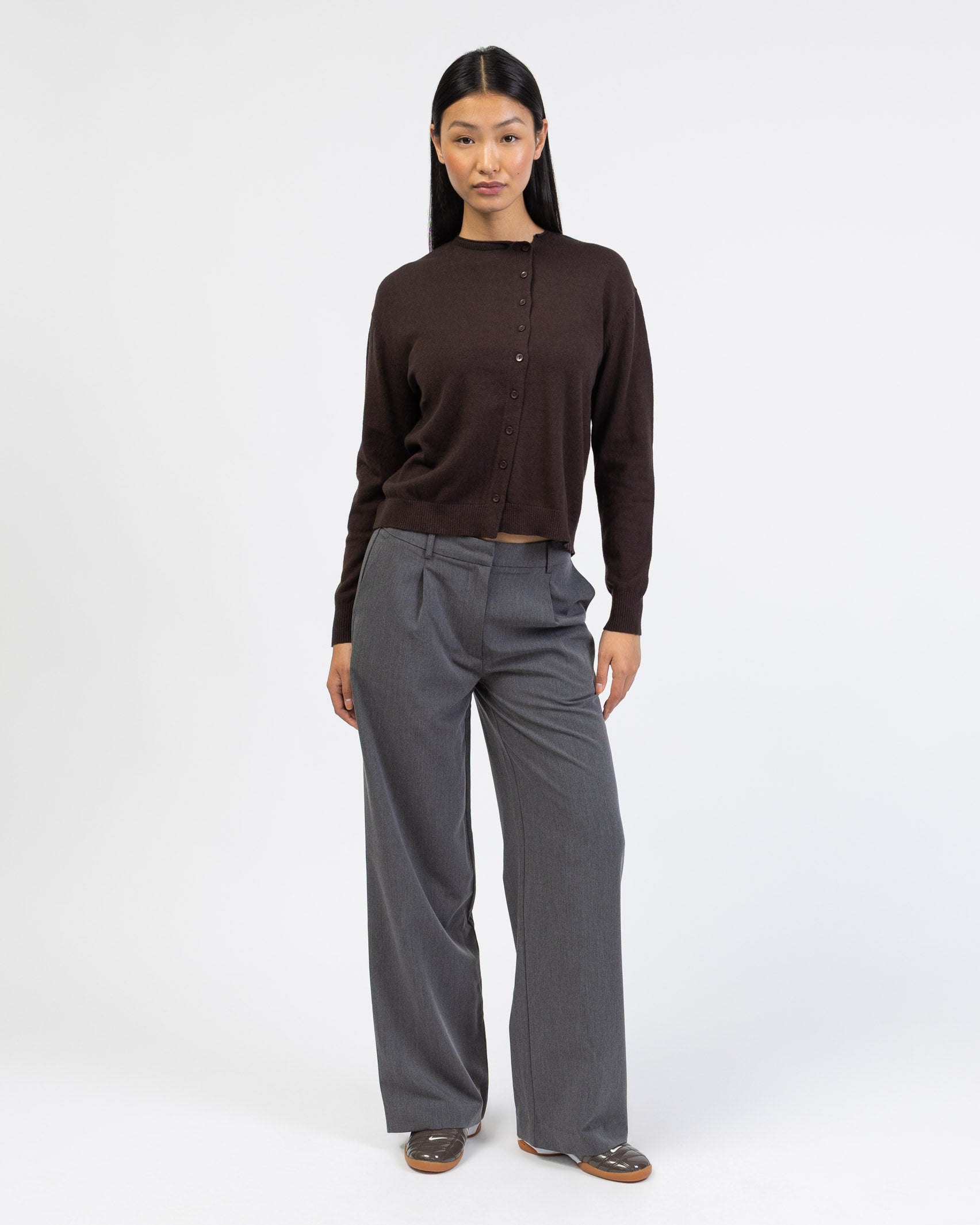 Strickjacke mit asymmetrischer Knopfleiste mit grauer Hose kombiniert