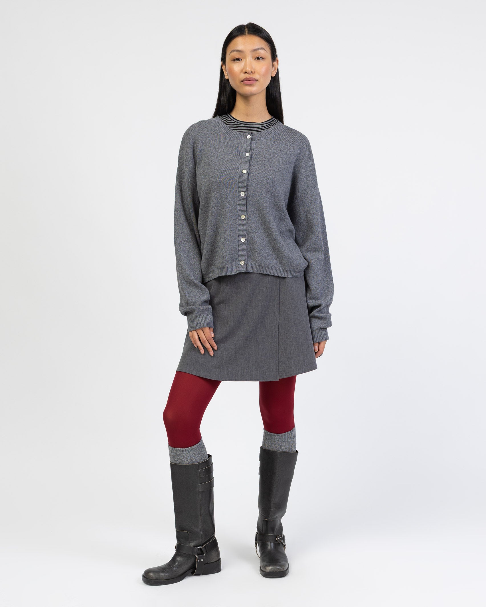 Klassische Strickjacke mit Rundhalsausschnitt kombiniert mit Miniskirt und Strumpfhose