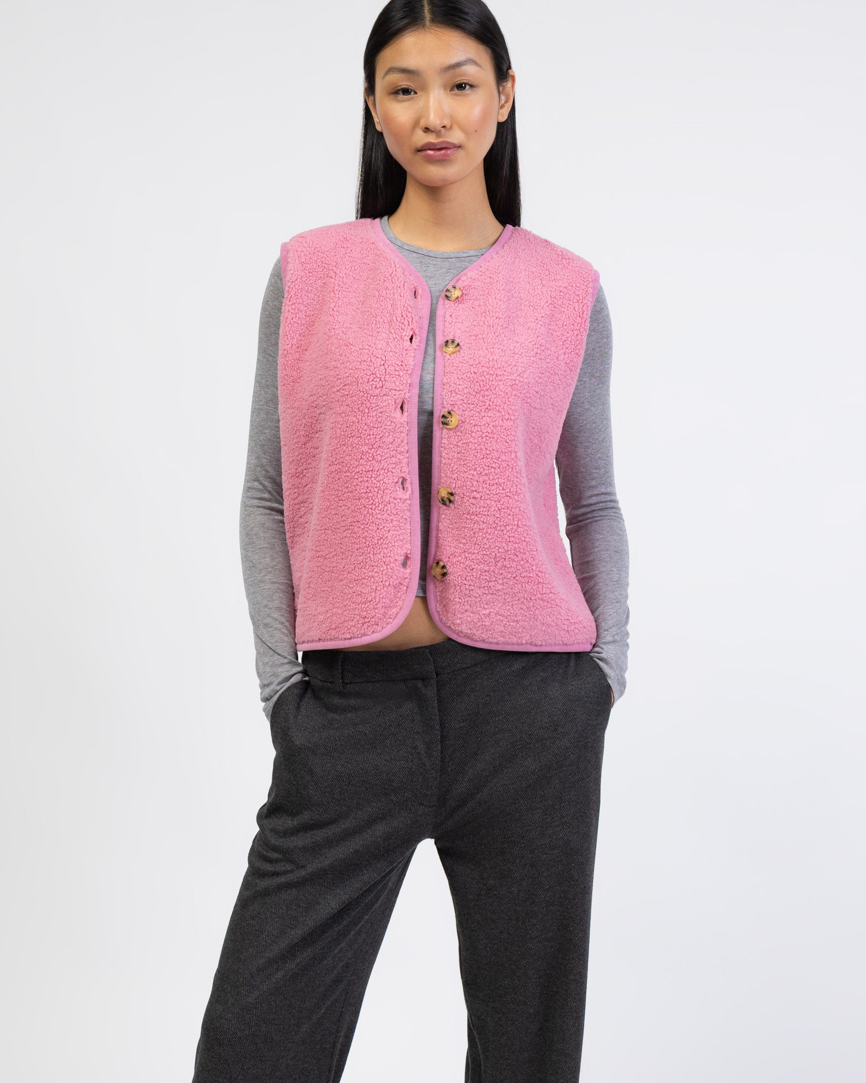 Einfarbige Teddyweste kombiniert mit grauem Langarmshirt und Hose