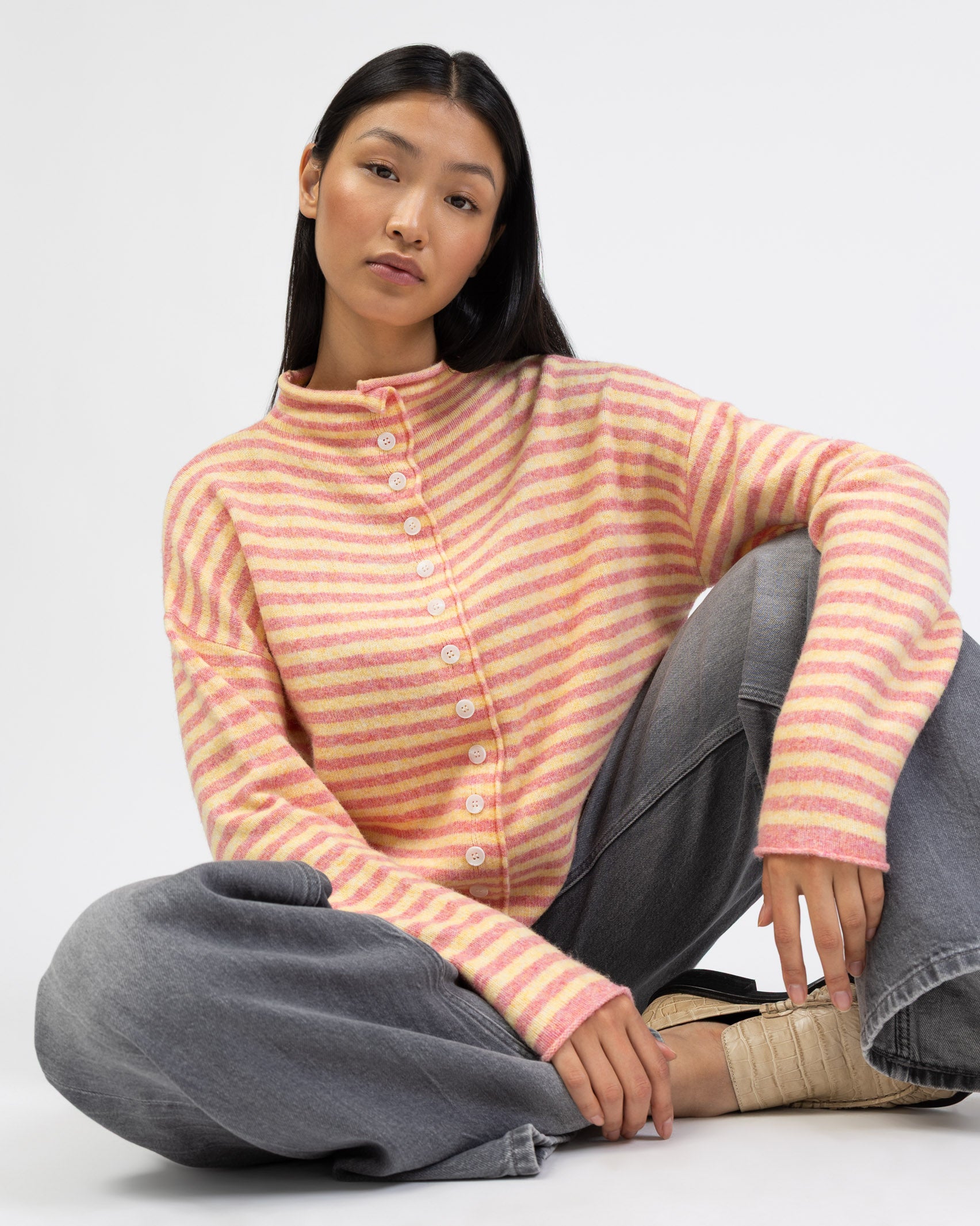 Gestreifte Strickjacke mit Stehkragen im Sitzen