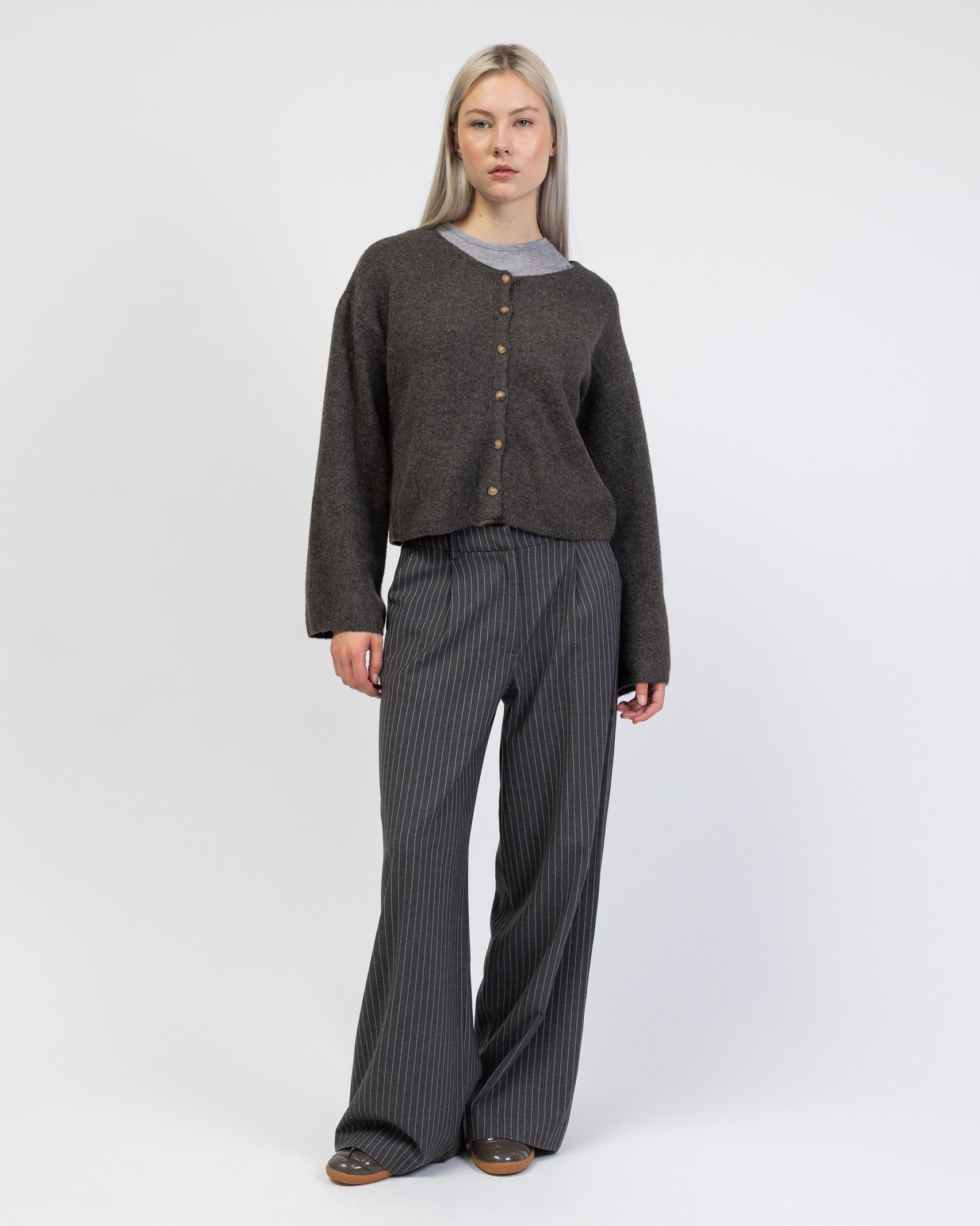 Einfarbige Strickjacke kombiniert mit Nadelstreifenhose