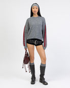 Strickpullover mit Streifendetails mit kurzer Shorts und Boots kombiniert