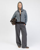 Gestreifte Strickjacke mit Kapuze kombiniert mit grauer Anzugshose