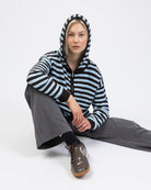 Gestreifte Strickjacke mit Kapuze sitzend