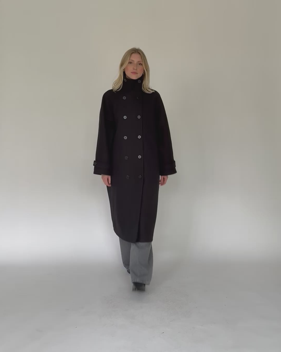 Langer Mantel mit hohem Kragen in Bewegung