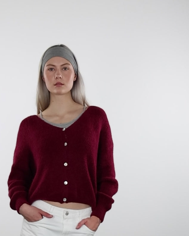 Strickjacke mit V-Ausschnittin Bewegung